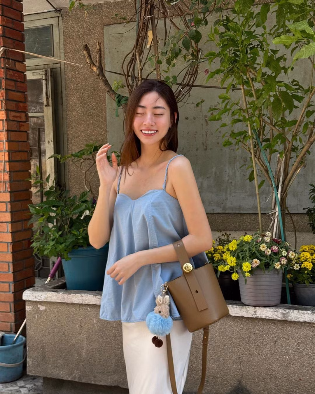 Hoa hậu Lương Thùy Linh có cách mix &amp; match thú vị với các mẫu áo hai dây, bra-top. Người đẹp mang đến cảm giác dịu dàng khi phối áo hai dây dáng dài cùng chân váy và túi xách hot trend. Khi ra biển, nàng hậu diện bra-top kết hợp cùng áo sơ mi và mũ bucket trẻ trung.