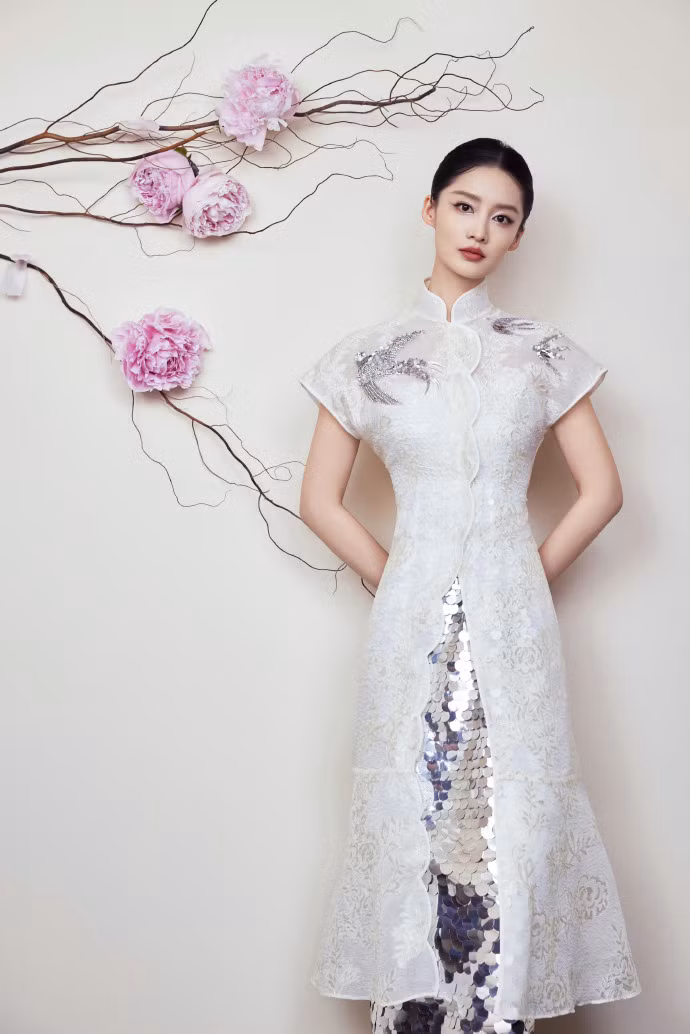 Diễn viên Lý Thấm lựa chọn váy dạ hội đính kim tuyến cầu kỳ thay vì trang phục truyền thống được hé lộ trước thềm sự kiện. Tạo hình được cho là không mấy ăn khớp chủ đề đêm hội.