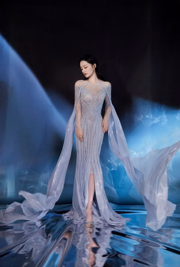 Diễn viên Lý Thấm lựa chọn váy dạ hội đính kim tuyến cầu kỳ thay vì trang phục truyền thống được hé lộ trước thềm sự kiện. Tạo hình được cho là không mấy ăn khớp chủ đề đêm hội.