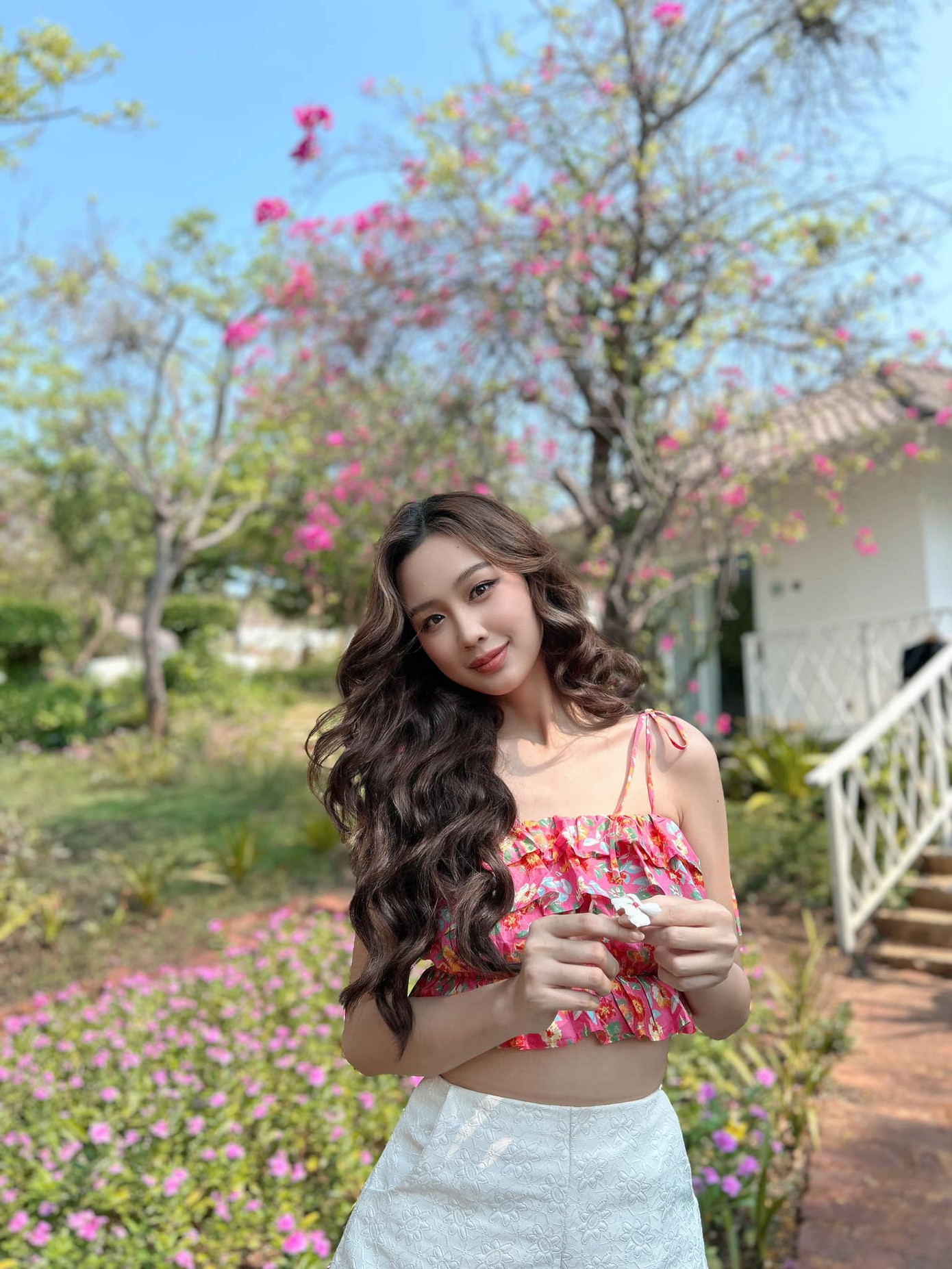 Hoa hậu Bảo Ngọc chào Hè với mẫu áo hai dây bèo nhún xếp lớp màu đỏ hồng ấn tượng.