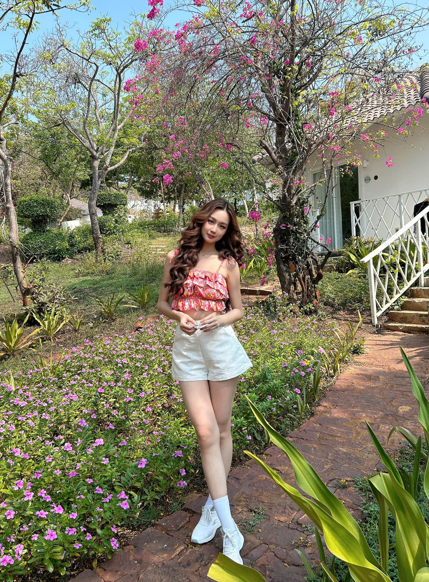 Hoa hậu Bảo Ngọc chào Hè với mẫu áo hai dây bèo nhún xếp lớp màu đỏ hồng ấn tượng.