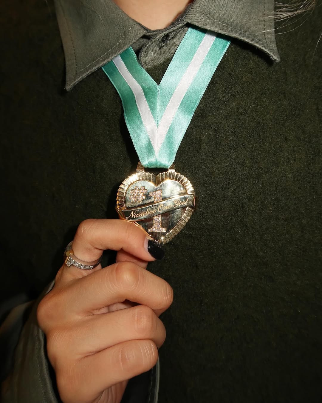 Điểm nhấn của tạo hình nằm ở tấm huy chương number one girl của thương hiệu trang sức mà cô nàng đang làm nữ đại sứ toàn cầu.