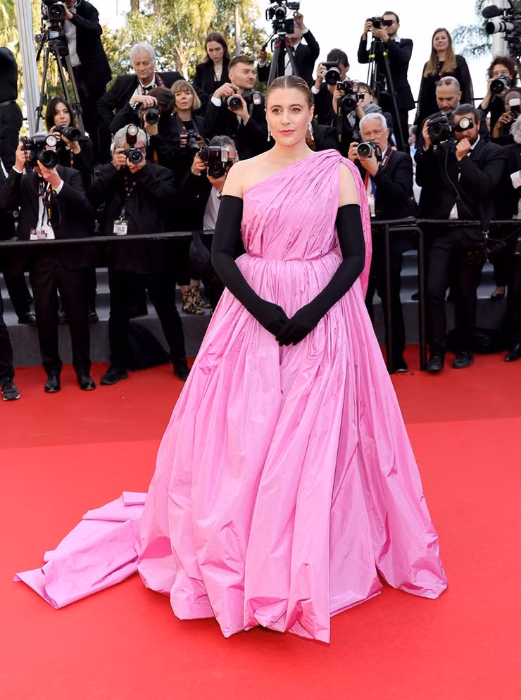 Chủ tịch ban giám khảo LHP Cannes 2024 Greta Gerwig diện thiết kế lệch vai tông hồng đến từ thương hiệu Balenciaga.