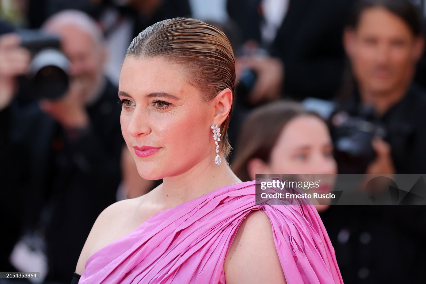 Chủ tịch ban giám khảo LHP Cannes 2024 Greta Gerwig diện thiết kế lệch vai tông hồng đến từ thương hiệu Balenciaga.