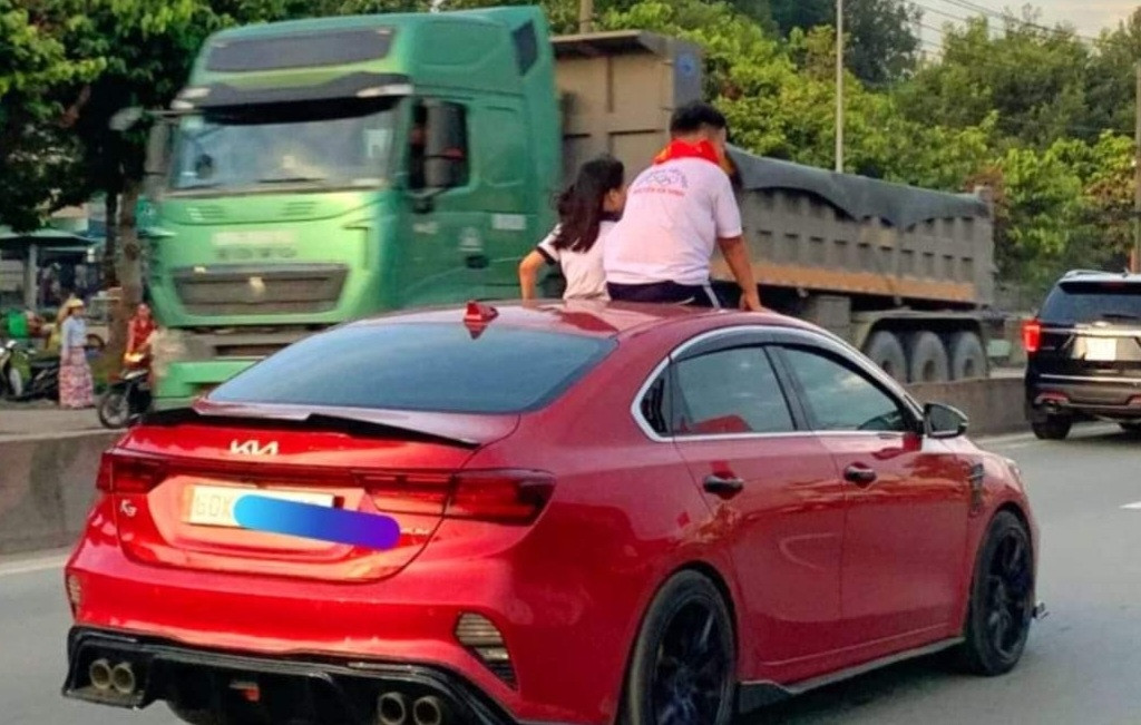 2 trẻ em chui lên nóc khi xe ô tô đang lưu thông
