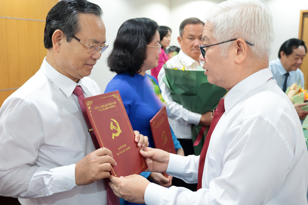 Bí thư Tỉnh ủy Bình Dương Nguyễn Văn Lợi (bìa phải) trao quyết định cho ông Nguyễn Văn Dành