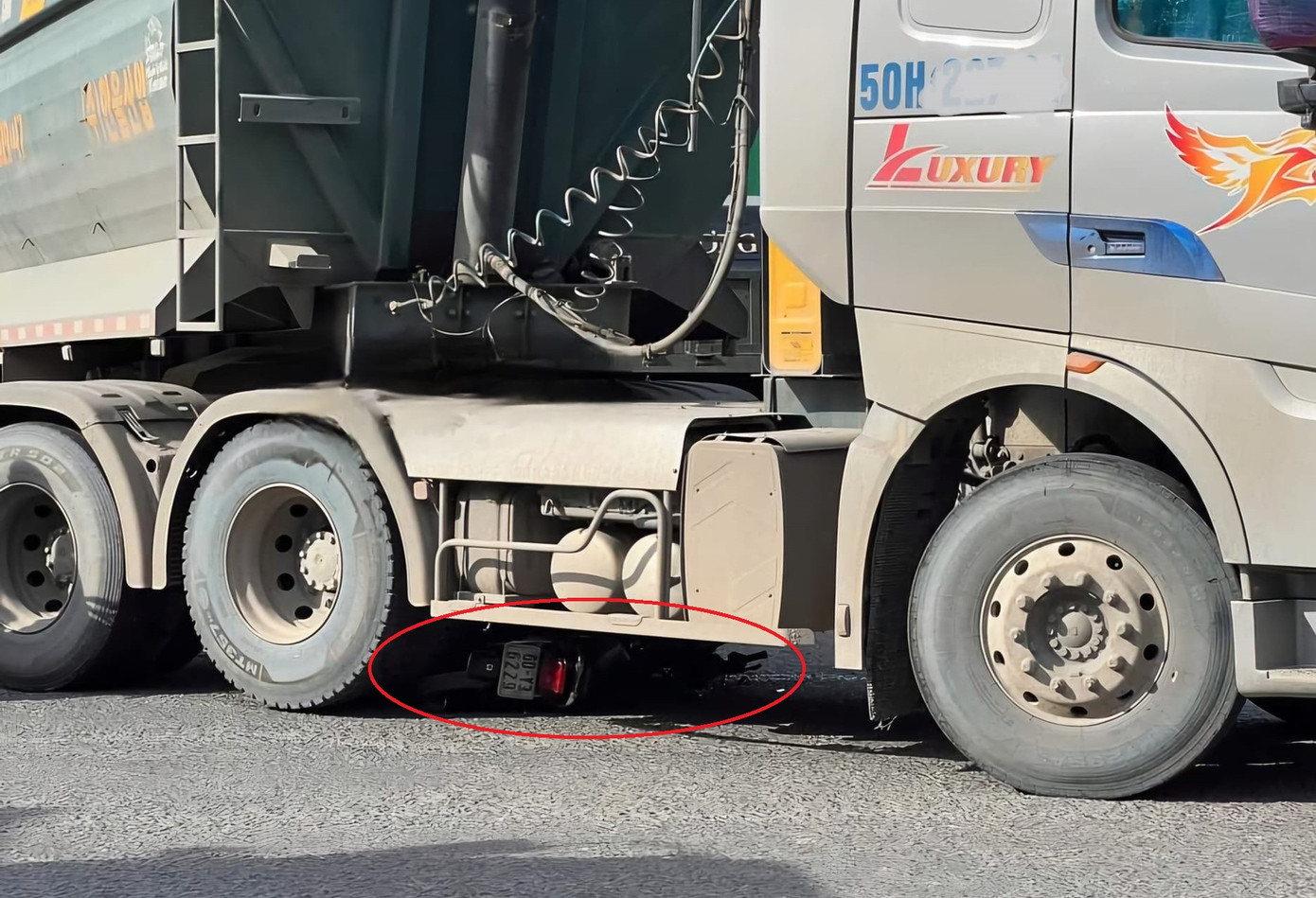 Xe máy nằm lọt dưới gầm xe ben Xe máy nằm lọt dưới gầm xe ben