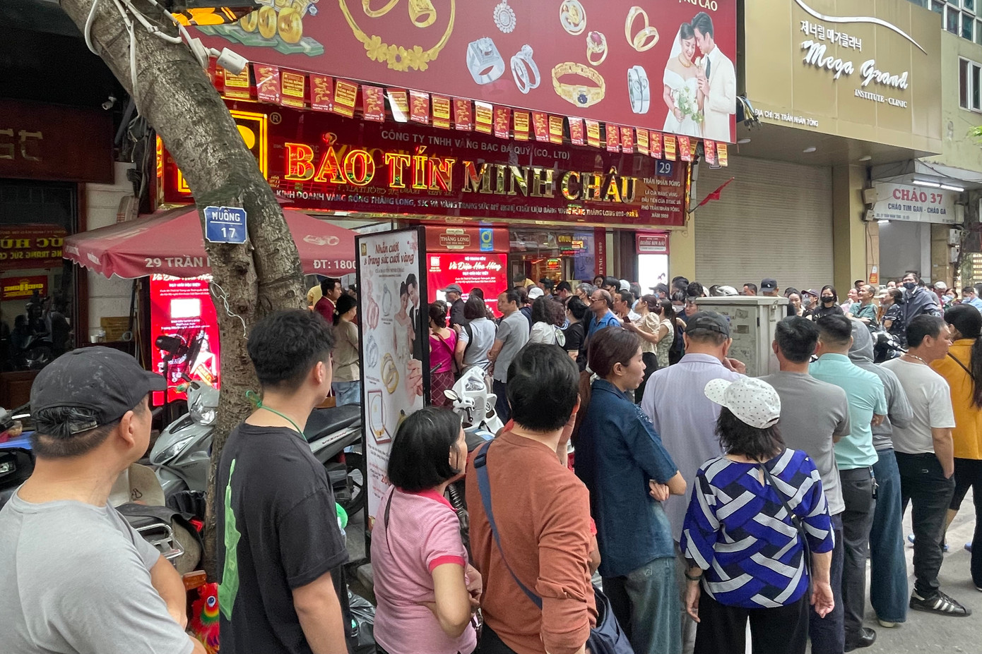 Càng về trưa, dòng người kéo đến ngày càng đông và xếp thành nhiều hàng, quây kín cửa hàng vàng.