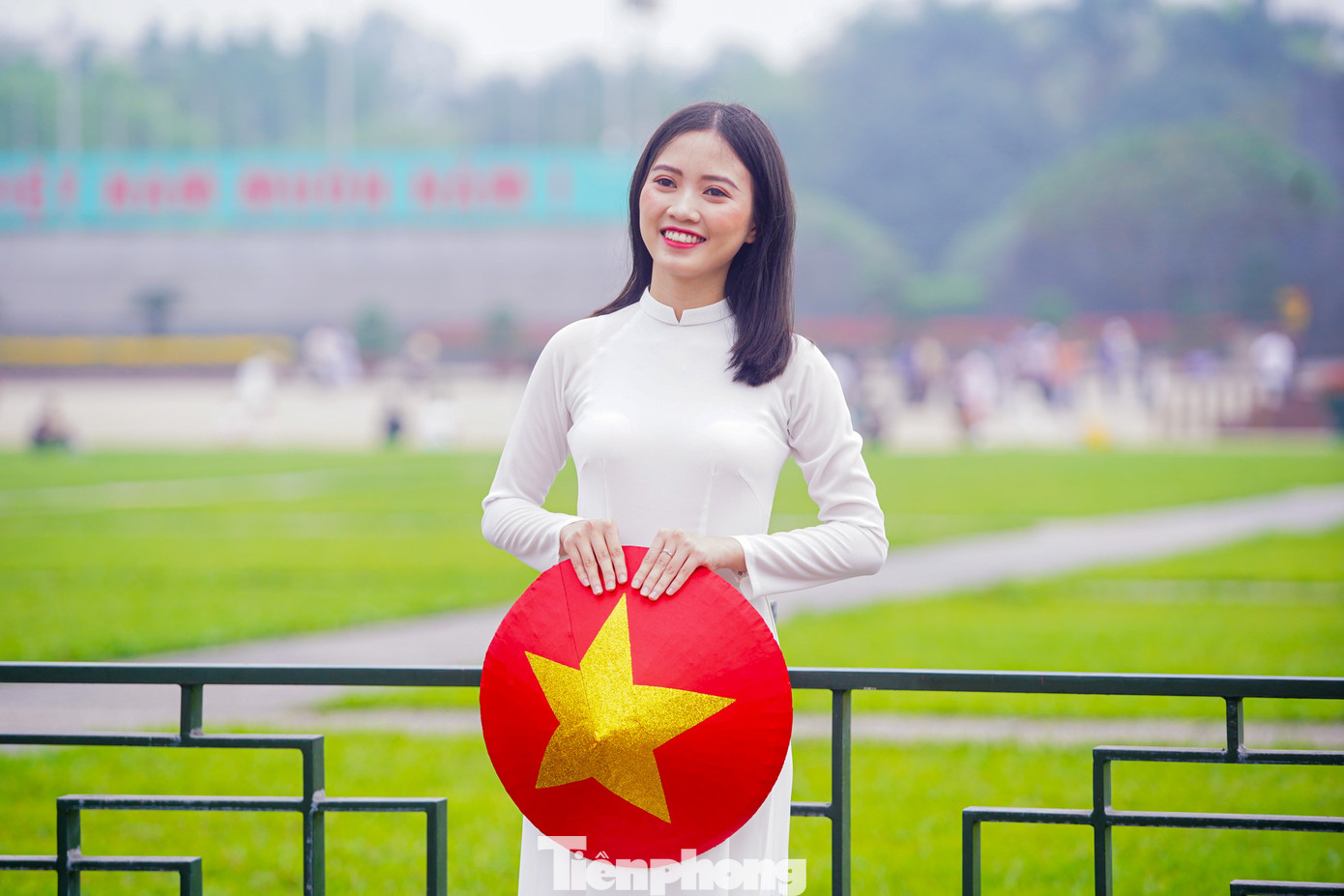 Thiếu nữ xúng xính trong bộ áo dài cùng cờ đỏ sao vàng chụp ảnh trước Quảng trường Ba Đình.