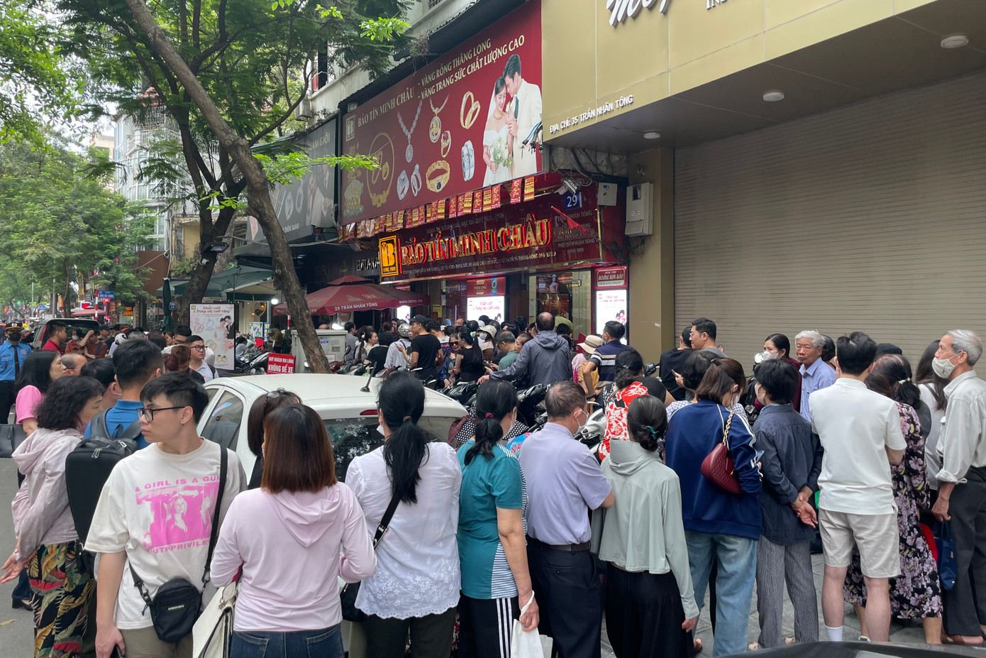 Càng về trưa, dòng người kéo đến ngày càng đông và xếp thành nhiều hàng, quây kín cửa hàng vàng.