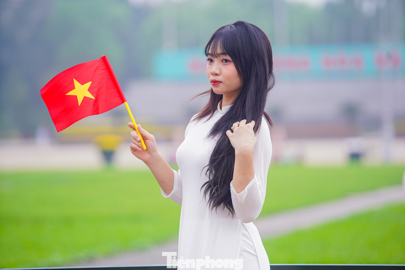 Thiếu nữ xúng xính trong bộ áo dài cùng cờ đỏ sao vàng chụp ảnh trước Quảng trường Ba Đình.