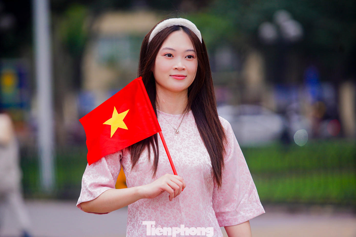 Thiếu nữ xúng xính trong bộ áo dài cùng cờ đỏ sao vàng chụp ảnh trước Quảng trường Ba Đình.