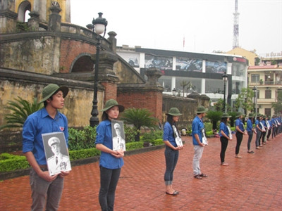 Hàng trăm Đoàn viên thanh niên cầm di ảnh Đại tướng Võ Nguyên Giáp đứng xếp hàng trang trọng ở cổng Bình quan.