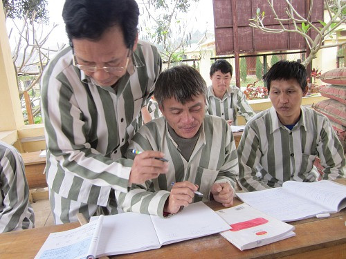 Sầm Đức Xương đang dạy chữ cho các bạn tù