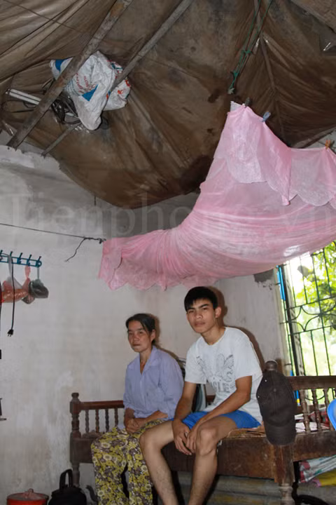 Để tránh dột, phía trên của chiếc giường duy nhất trong nhà, một tấm nilon được căng lên. Sau vài trận mưa vừa qua, nước vẫn đọng lại khá nhiều trên đó. Ảnh: Trường Phong 