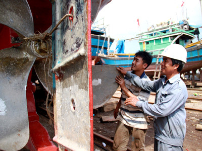 Thuyền trưởng trẻ Phạm Ngọc Tây và ông Cư kiểm tra lần cuối bánh lái con tàu mới trước giờ hạ thủy