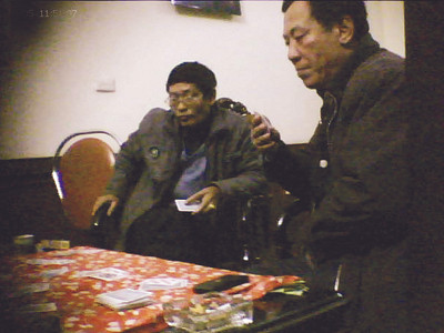 Ông Thởi, người cầm bài đeo kính