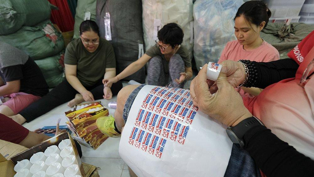 Các thành viên BTC dán biểu trưng lên nến, phục vụ cho buổi lễ dâng hương, tri ân tại nghĩa trang Hàng Dương chiều tối 26/3, tưởng niệm hơn 20.000 anh hùng, liệt sỹ, các trí sĩ yêu nước đã ngã xuống trên mảnh đất Côn Đảo trong cuộc đấu tranh giành độc lập, tự do cho tổ quốc, cho dân tộc. Đây là một trong những hoạt động chính trong chuỗi sự kiện bên lề của Tiền Phong Marathon 2022.