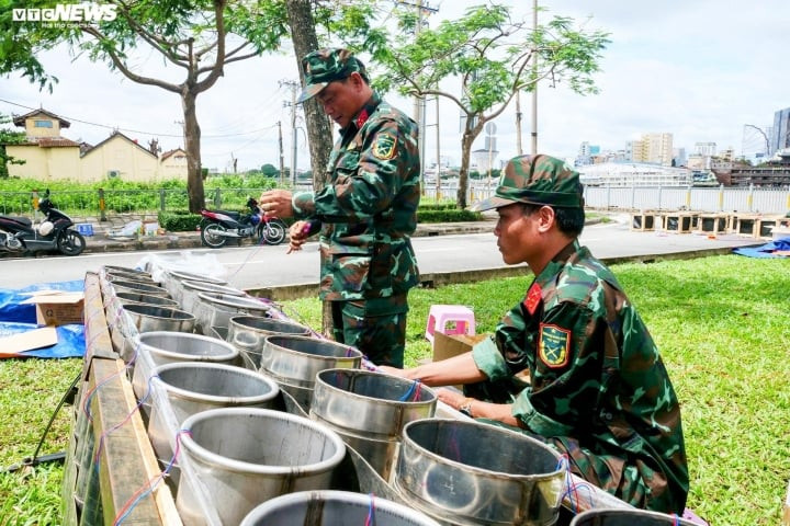 Lực lượng chức năng đang khẩn trương cho pháo vào nòng, đấu nối dây điện kết nối phòng điều khiển.