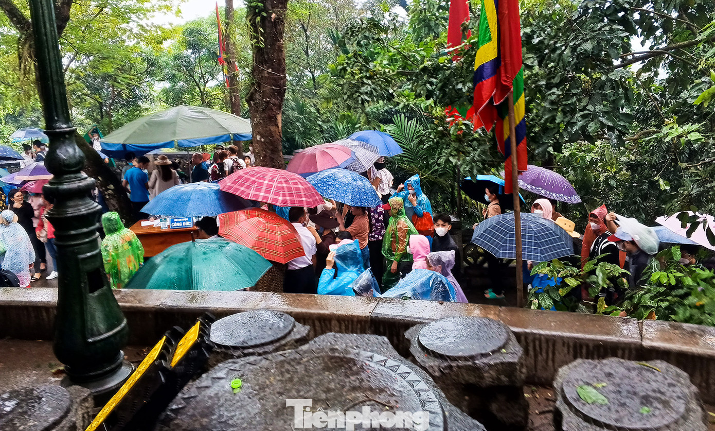 Tại khu vực đền Thượng, hơn 9h sáng, trời mưa lất phất. Người dân mặc áo mưa và cầm ô di chuyển lên dâng hương. Tại khu vực đền Thượng, hơn 9h sáng, trời mưa lất phất. Người dân mặc áo mưa và cầm ô di chuyển lên dâng hương.