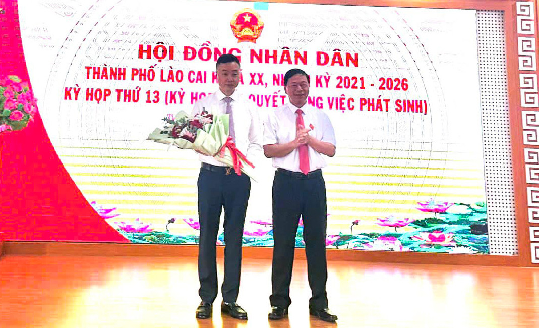 Tân Phó Chủ tịch UBND thành phố Lào Cai Nguyễn Tiến Ngân (cầm hoa).