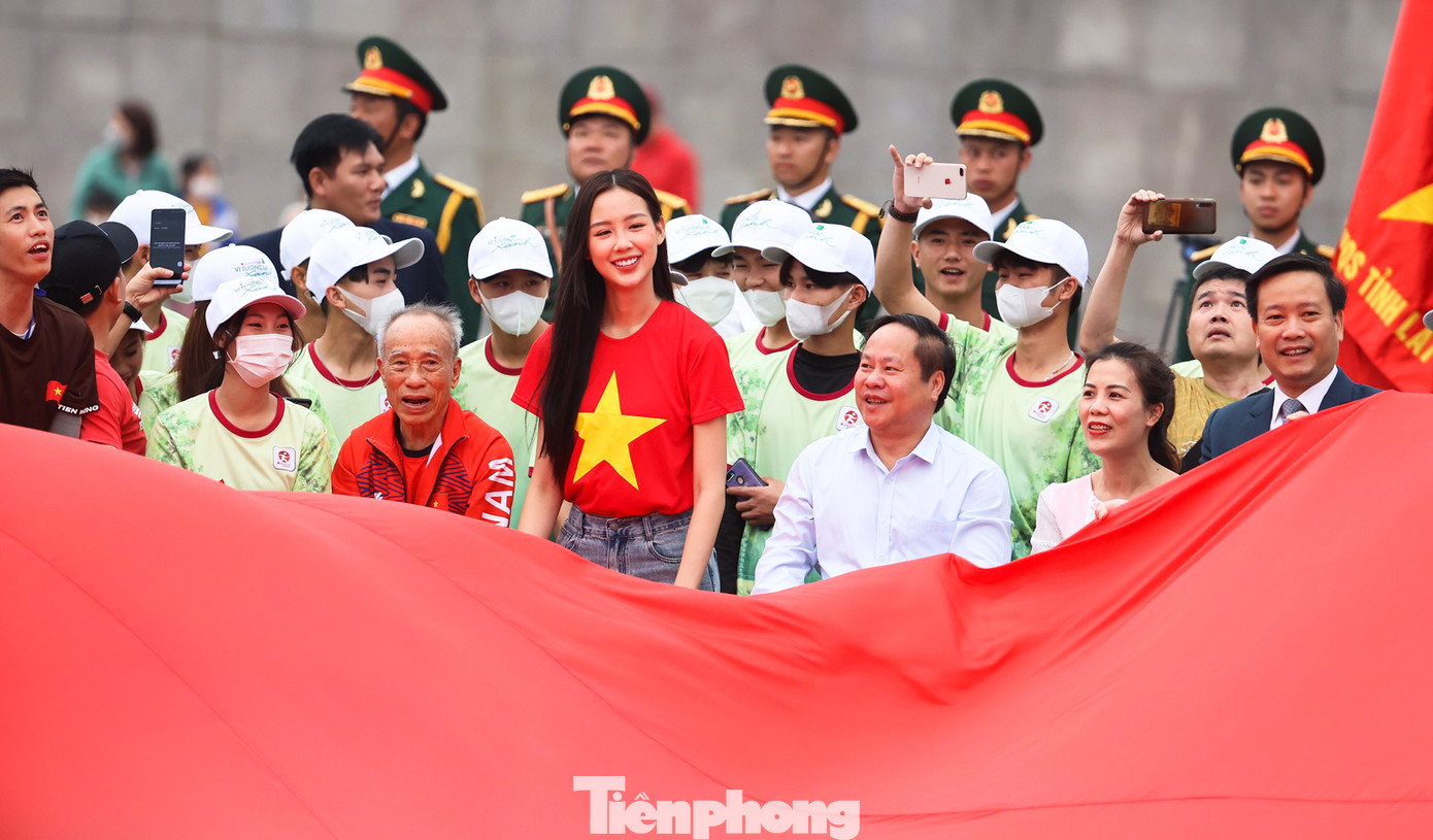 Ông Tống Thanh Hải (áo trắng) - Phó Chủ tịch Thường trực UBND tỉnh Lai Châu cùng vận động viên và du khách trải lá cờ Tổ quốc rộng 540m2 trên Quảng trường Nhân dân.