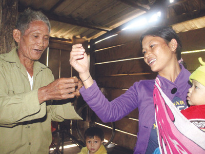 Già Hồ Khoa buộc chỉ tay cho các thành viên trong gia đình . Ảnh: Nguyễn Huy Già Hồ Khoa buộc chỉ tay cho các thành viên trong gia đình