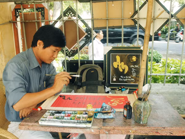 Miệt mài với câu đối ngày xuân. Ảnh: T.N.A 