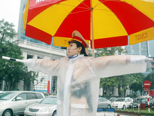 Mưa rét nhưng Thiếu úy Nguyễn Mai Huyền vẫn thấy "nóng" khi lần đầu trực tiếp phân luồng giao thông. Ảnh: Minh Đức.