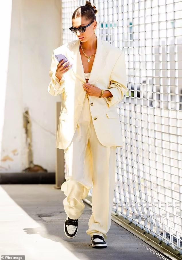 Bà xã Justin Bieber mặc set đồ blazer quá khổ màu vàng chanh với quần thụng &quot;ton-sur-ton&quot;, kết hợp đôi Nike Jordan màu đen, cùng kính mắt và loại phụ kiện như dây chuyển vàng, vòng tay, bông tai tròn và nhẫn. Mái tóc được búi lên gọn gàng.