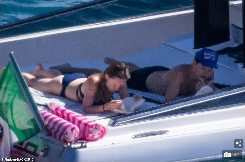 Sau đó, Olivia và tình trẻ kém 10 tuổi nằm thư giãn trên boong tàu đọc sách.