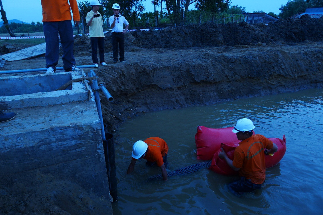 Khi kéo đến hầm xử lý cáp, công nhân phải nhanh chóng gỡ phao đỡ cáp để đưa cáp vào con lăn