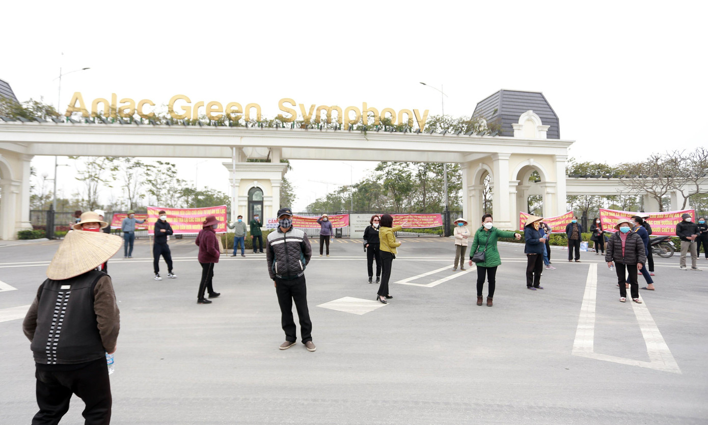 Người dân xã Vân Canh tập trung băng rôn phản đối, yêu cầu chủ đầu tư dỡ bỏ tường bê tông kiên cố, mở lối đi. Ảnh chụp ngày 26/2.