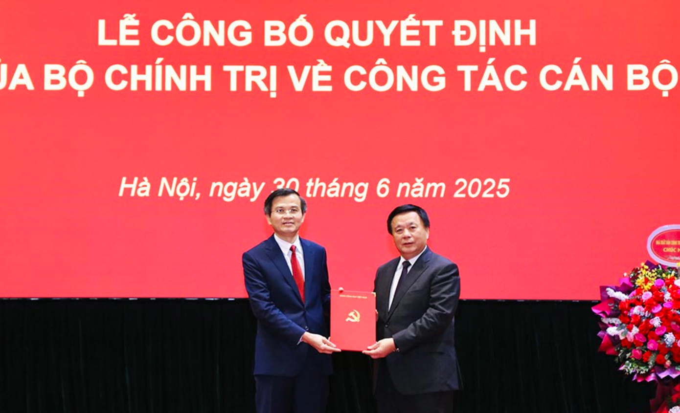 Ông Nguyễn Xuân Thắng, Ủy viên Bộ Chính trị, Giám đốc Học viện Chính trị Quốc gia Hồ Chí Minh, Chủ tịch Hội đồng Lý luận Trung ương trao Quyết định của Bộ Chính trị cho đồng chí Đoàn Minh Huấn.