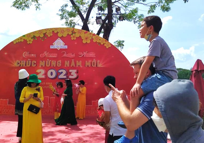 Người cha cõng con trai đi xem đường hoa xuân ngày mồng 2 Tết Quý Mão Người cha cõng con trai đi xem đường hoa xuân ngày mồng 2 Tết Quý Mão