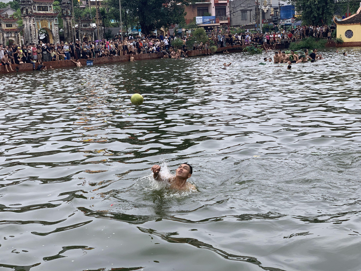 Không chỉ bắt vịt, người tham gia lễ hội còn vớt bưởi, vớt dừa trên mặt ao Chùa ném cho người xem bất kể quen biết hay không. Mọi người trên bờ dưới ao đều hỉ hả.