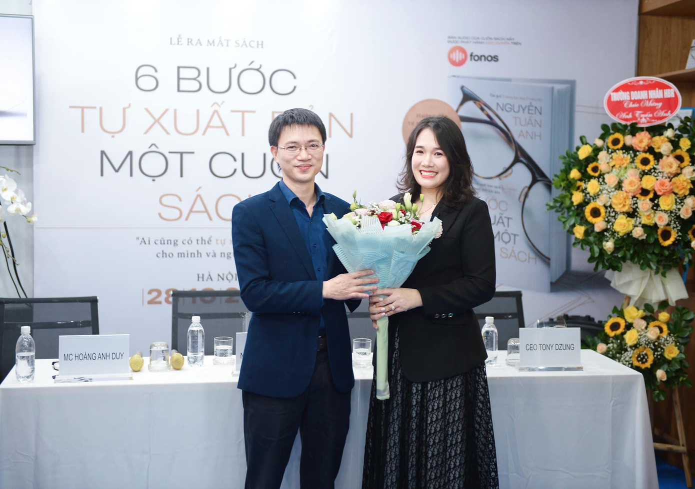 Tác giả, nhà báo Nguyễn Tuấn Anh tặng hoa cảm ơn CEO Nguyễn Mến với tư cách khách mời tại lễ ra mắt sách "6 bước tự xuất bản một cuốn sách". Ảnh: Dương Triều.
