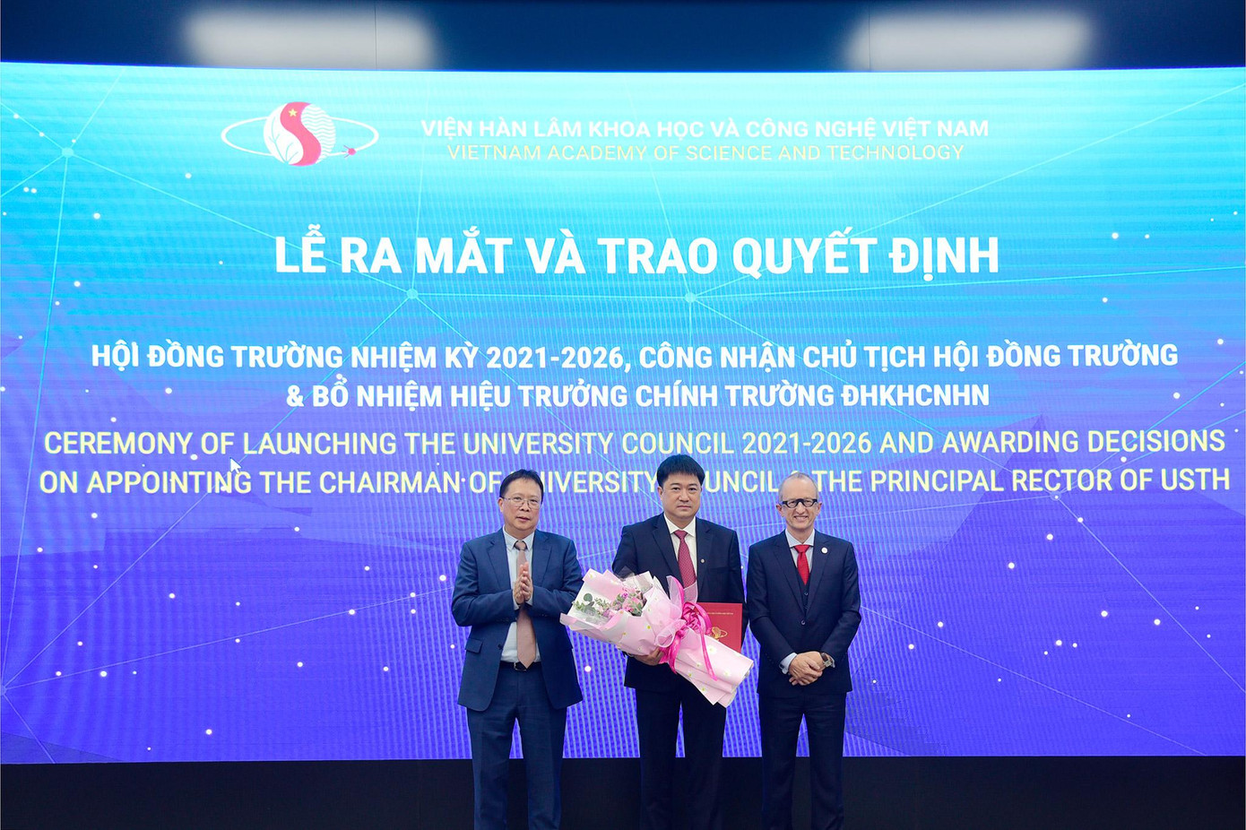 GS. VS. Châu Văn Minh - Chủ tịch Viện Hàn lâm Khoa học và Công nghệ Việt Nam sẽ trao Quyết định công nhận Chủ tịch Hội đồng trường nhiệm kỳ 2021-2026 đối với GS. TS. Chu Hoàng Hà - Phó Chủ tịch Viện Hàn lâm và trao Quyết định bổ nhiệm Hiệu trưởng chính USTH đối với GS. Jean-Marc Lavest (ảnh dưới).