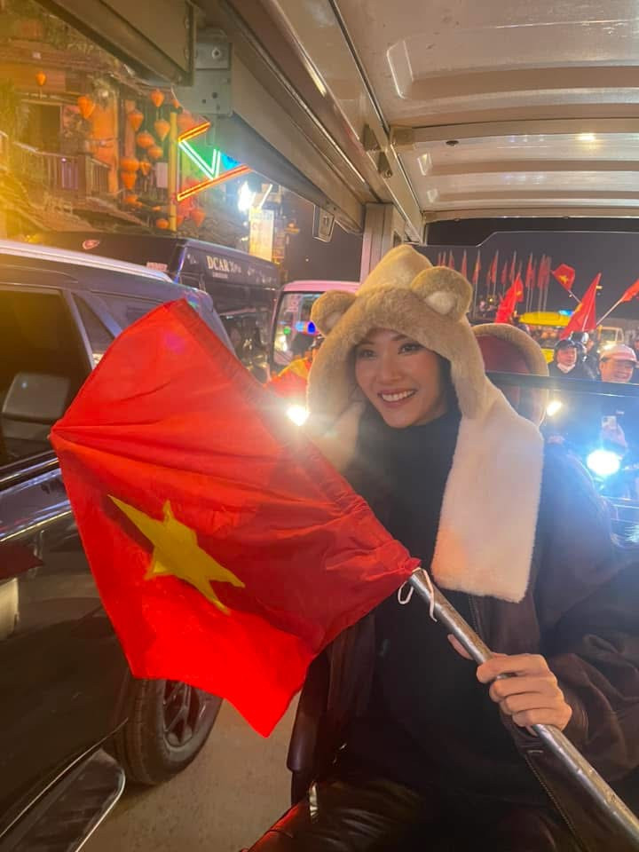 Á hậu Hoàng Thùy cầm cờ hòa vào dòng người trên phố. &quot;Đi bão! Không nói nhiều, Việt Nam vô địch&quot;, người đẹp chia sẻ.