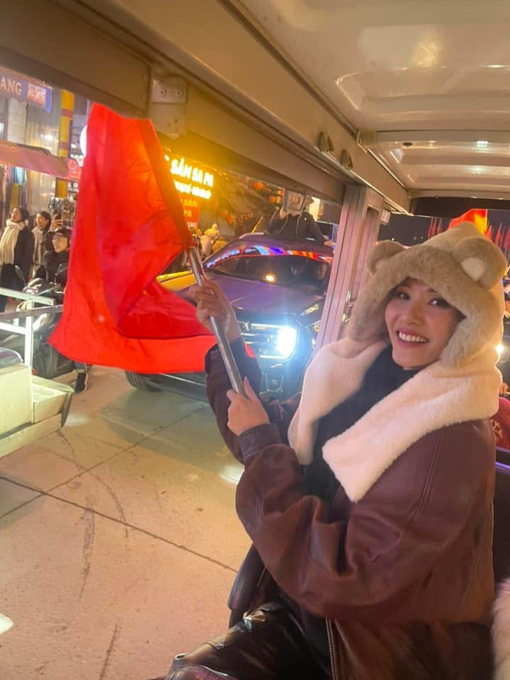 Á hậu Hoàng Thùy cầm cờ hòa vào dòng người trên phố. &quot;Đi bão! Không nói nhiều, Việt Nam vô địch&quot;, người đẹp chia sẻ.