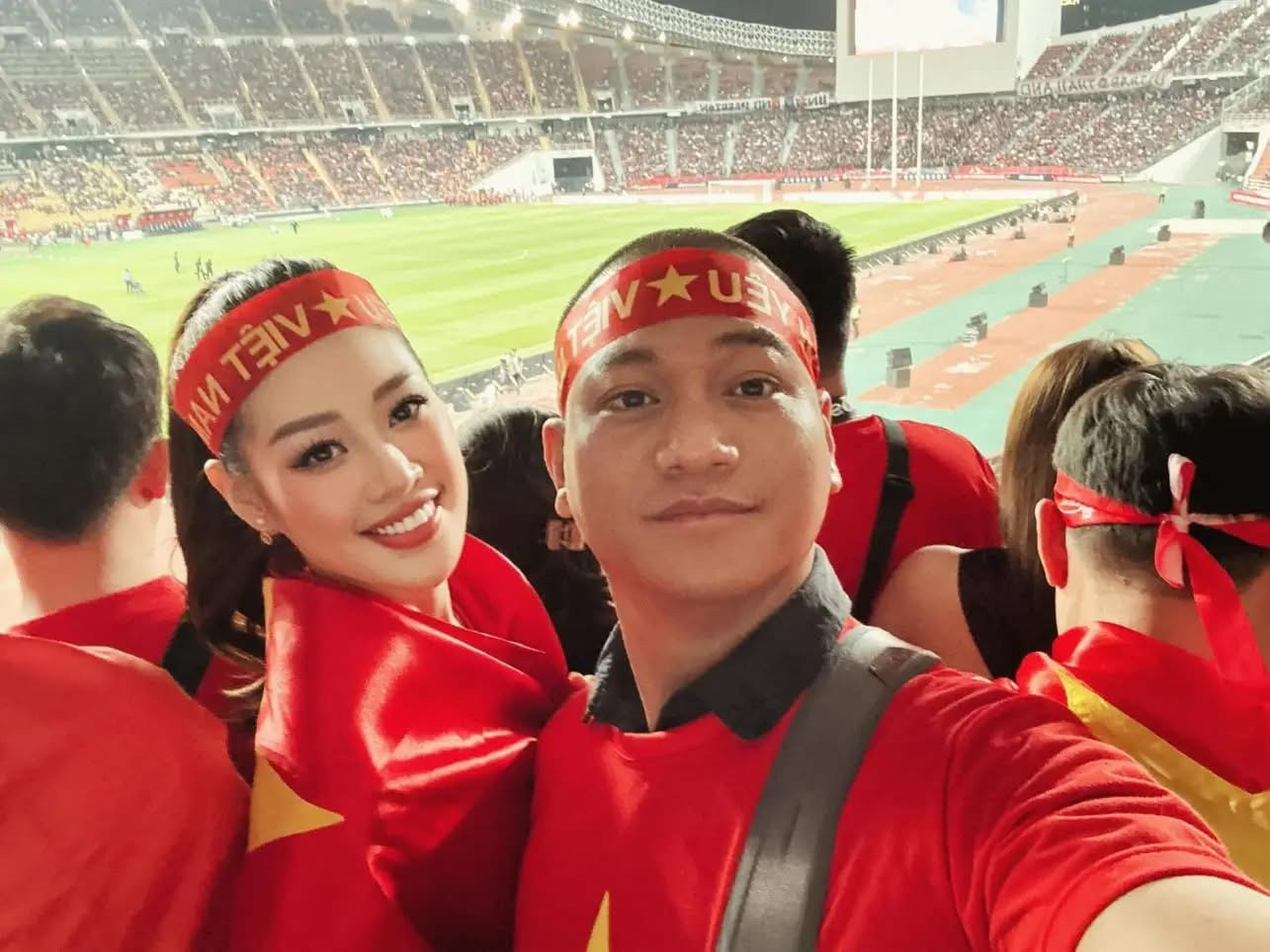 Vợ chồng hoa hậu Khánh Vân chụp ảnh trên sân Rajamangala trong trận đấu giữa Việt Nam và Thái Lan.
