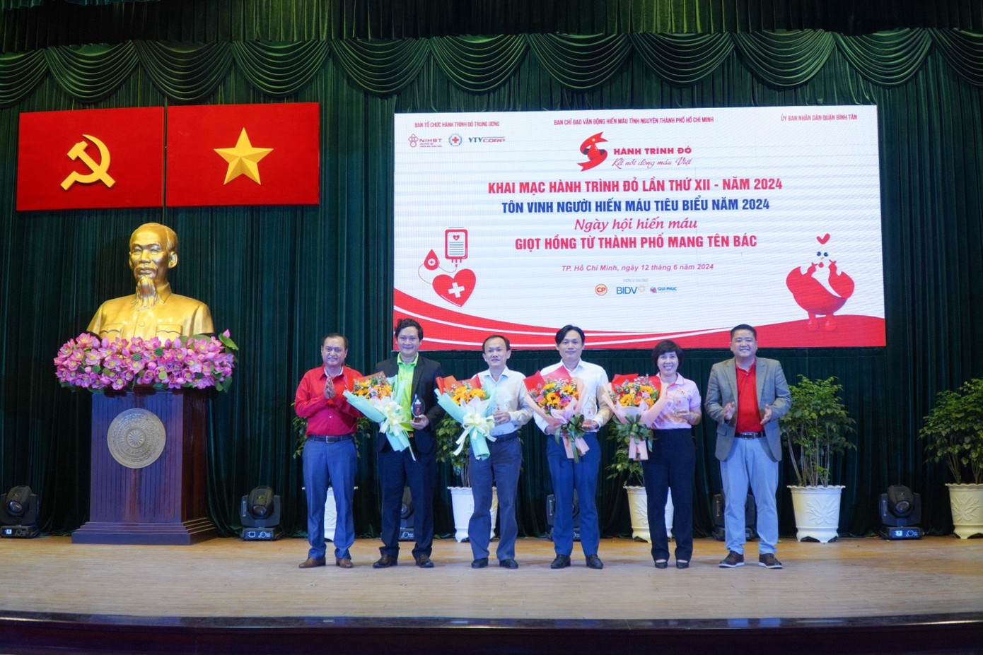 Ông Trần Thái Nguyên, Phó tổng giám đốc công ty TNHH SX-TM-DV Qui Phúc - đại diện công ty nhận hoa từ BTC chương trình (thứ ba từ trái sang)