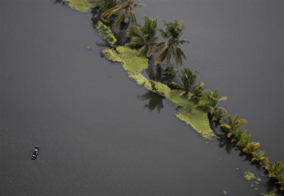 Một chiếc thuyền bé nhỏ bơi giữa biển nước ở vùng ngoại ô Bangkok. Ảnh chụp ngày 25-10