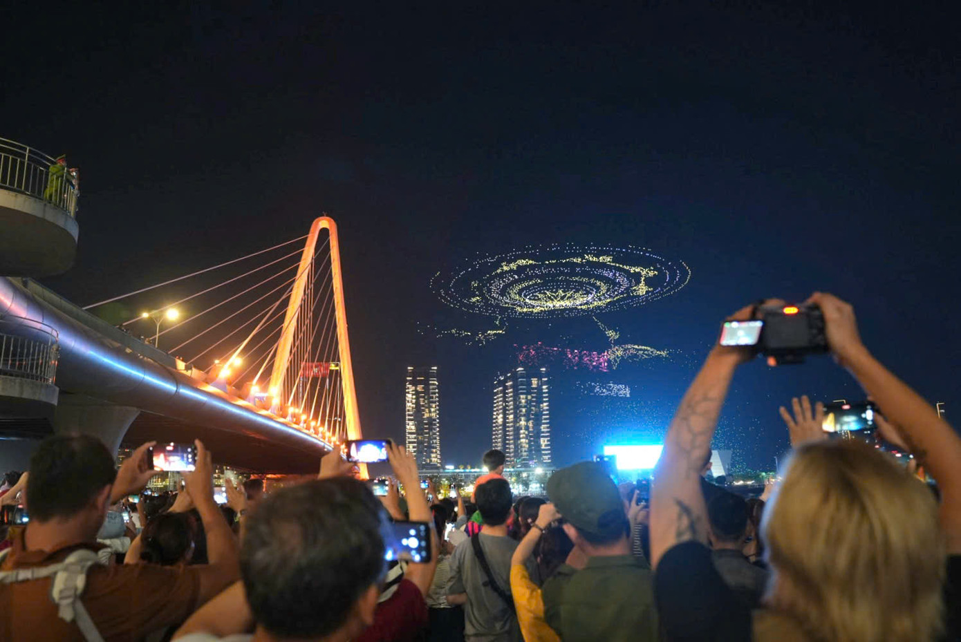 Người dân chăm chú theo dõi màn xếp hình 10.500 drone trên bầu trời. Ảnh: Hiếu Duy