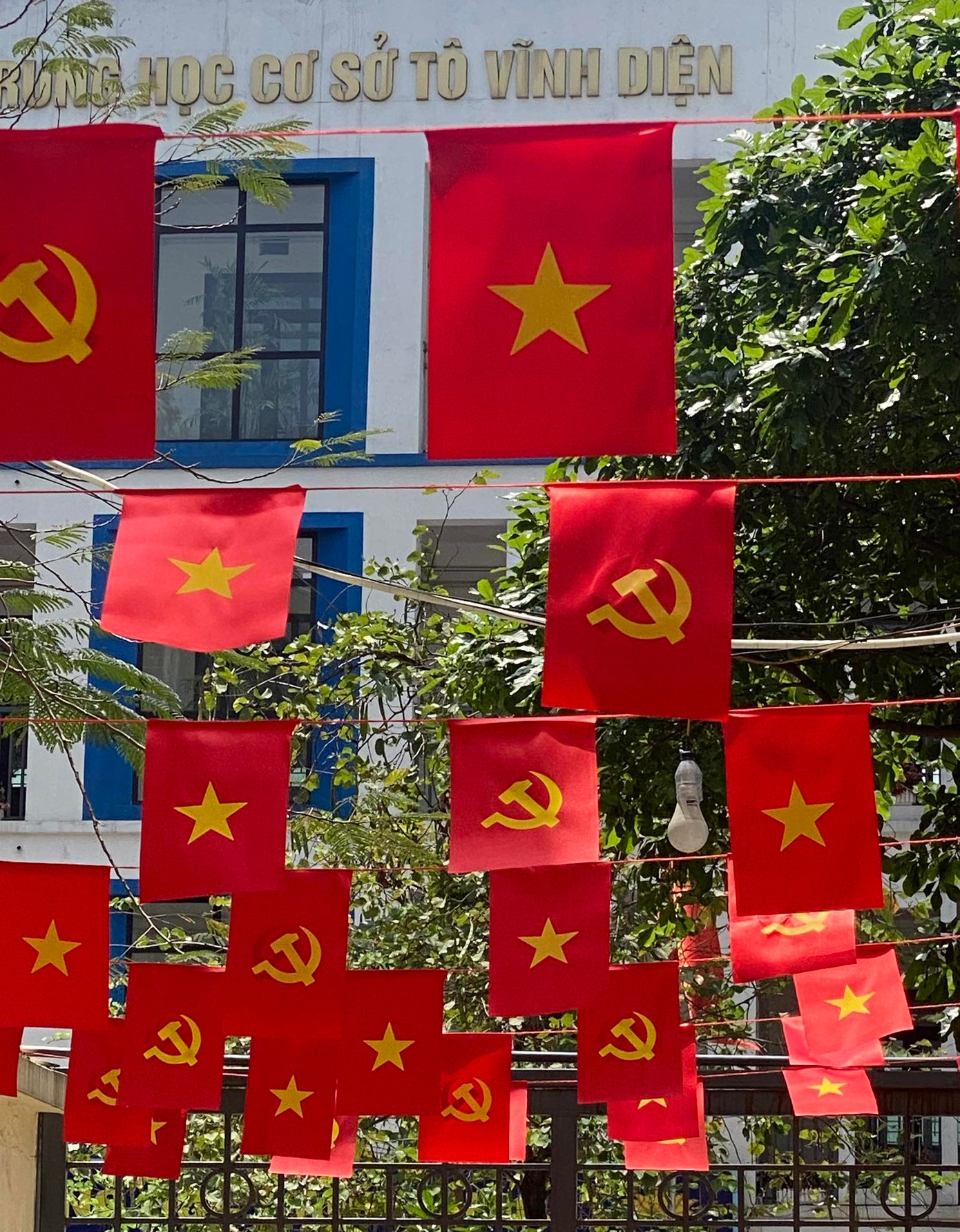 Không gian sân trường phủ đỏ màu cờ rực rỡ.