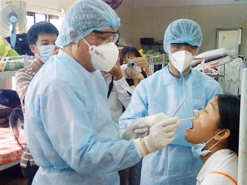 Bác sỹ Bệnh viện Nhiệt đới TPHCM lấy mẫu bệnh phẩm xét nghiệm cúm A/H1N1 - Ảnh: Lê Nguyễn