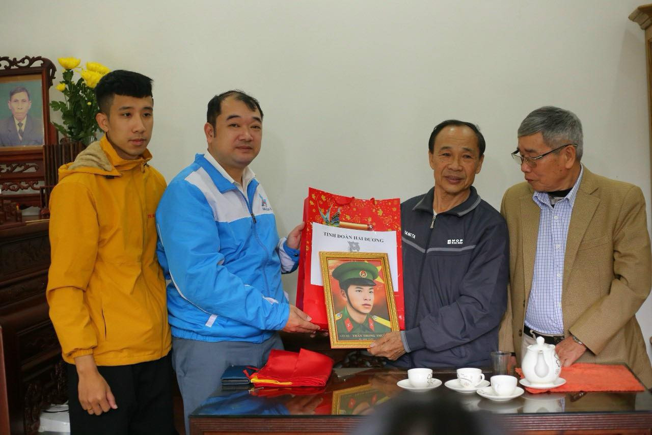 Đại diện Tỉnh Đoàn Hải Dương và nhóm Team Lee tặng quà Tết và ảnh phục dựng chân dung liệt sĩ tới gia đình liệt sĩ. Ảnh: TĐHD