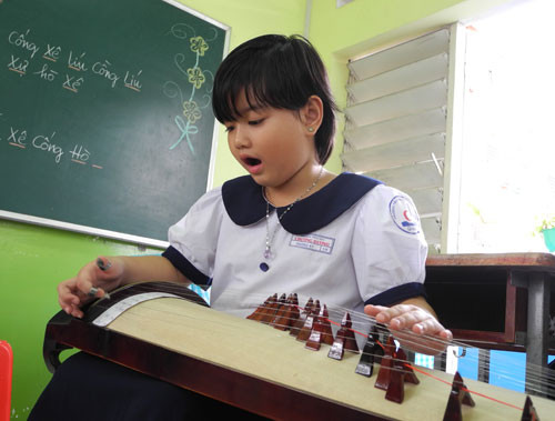 Cô bé Phương Kỳ, học sinh lớp 1, vừa gẩy đàn, vừa đọc hệ thống ngũ cung. Cô bé Phương Kỳ, học sinh lớp 1, vừa gẩy đàn, vừa đọc hệ thống ngũ cung