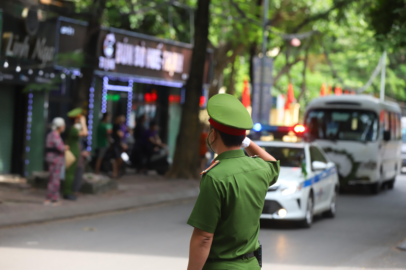 Người dân hai bên đường xúc động dõi theo đoàn xe đưa các liệt sĩ về Nhà tang lễ quốc gia, chuẩn bị cho Lễ tang theo nghi thức của lực lượng Công an Nhân dân.