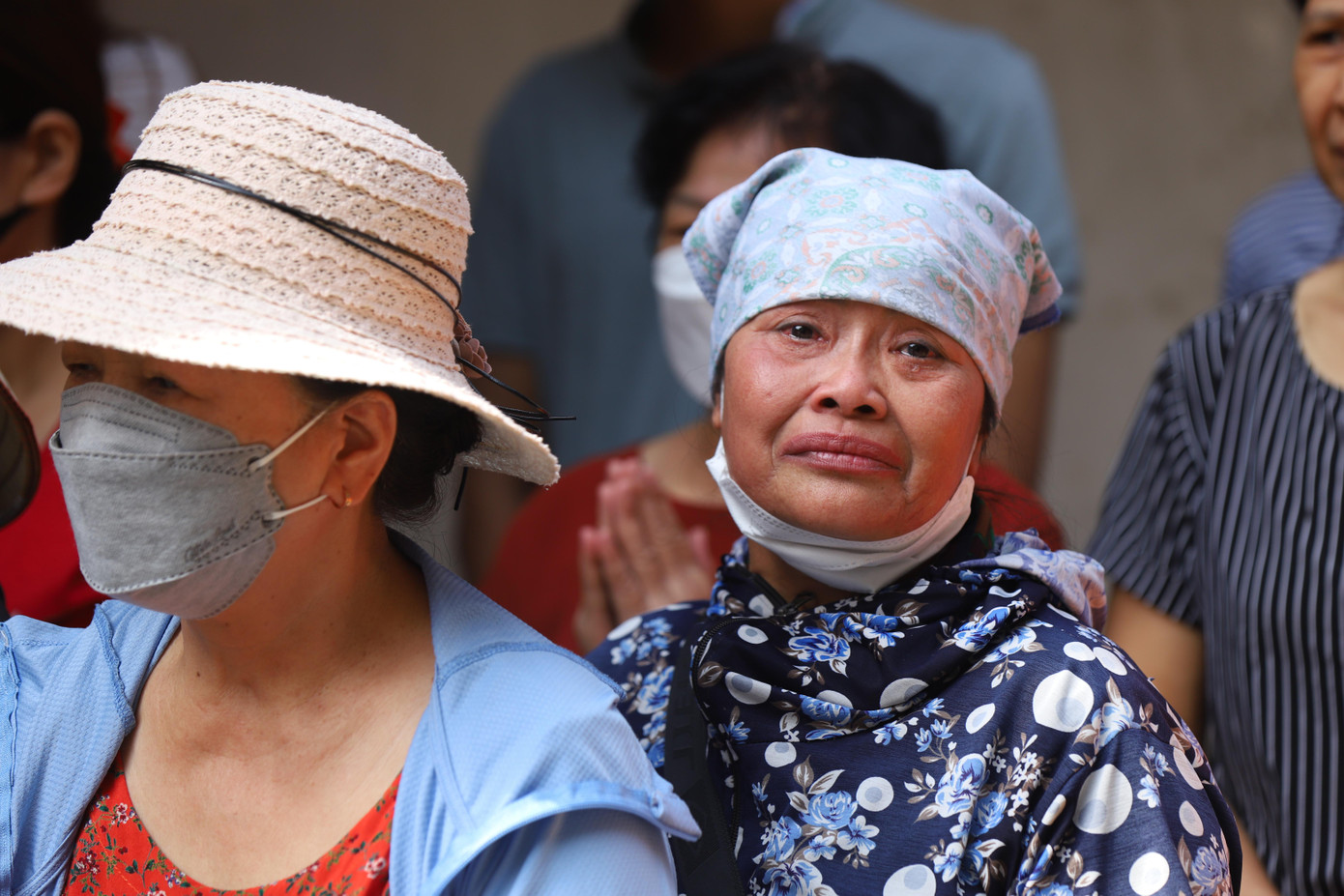 Người dân không kìm được nước mắt khi đoàn xe đưa linh cữu ba liệt sĩ đi qua.